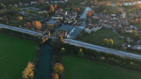 Toma-Aérea-De-Un-Dron-Giratorio-Hacia-Abajo-Del-Puente-Del-Visconteo-Al-Atardecer---Borghetto