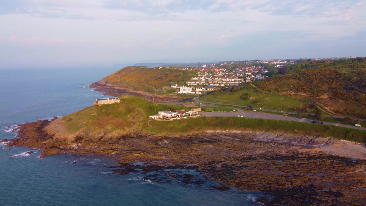 Vista aérea descendente de casas em Mumbles com a Praia de Bracelet Bay. Área imobiliária de luxo em Swansea. Perfeito para turismo, documentários de viagem. País de Gales, Reino Unido. 4K