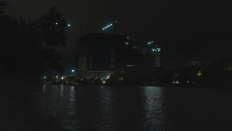night view of a building under construction near a lake