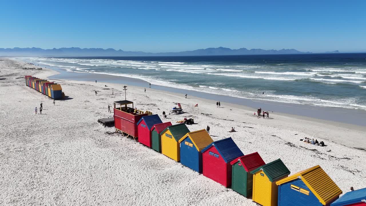 colorful beach huts on white sandy shore, vibrant seaside scenery with turquoise ocean and summer holiday atmosphere in South Africa Cape Town