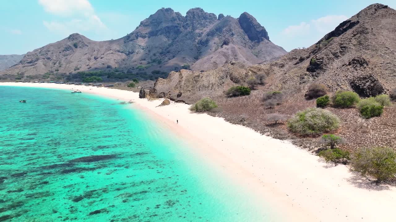 Man on the Pink Beach and breathtaking pristine seascape of Komodo Island, Indonesia.
