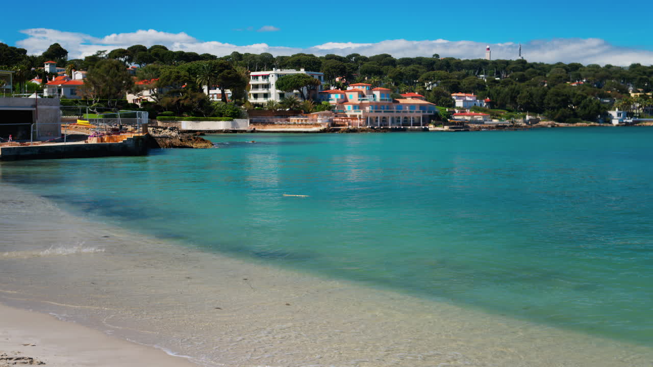 Waves crashing on the beach with the townscape of Bandol, France on the background