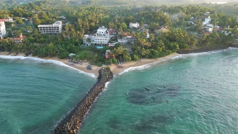 rotatin aerial shot of turtle bay beach resort at sunrise in mirissa, sri lanka