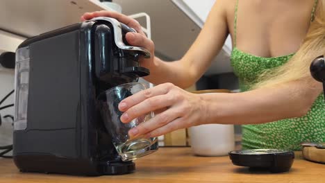 mujer haciendo café con una máquina de café