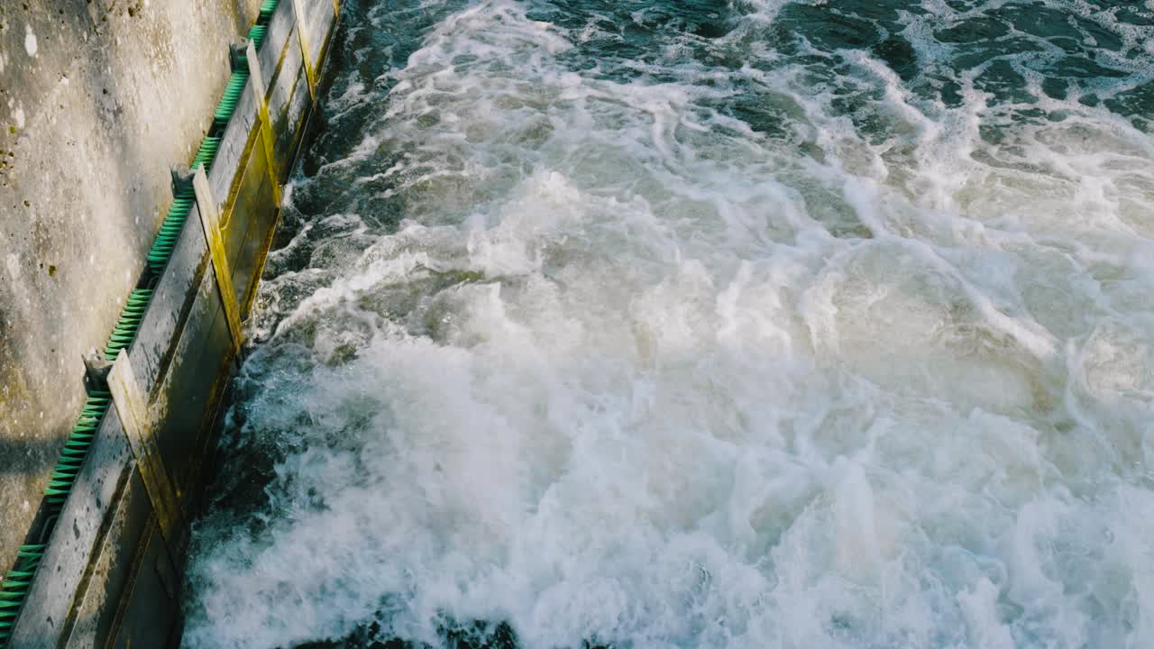 High angle shot over water that comes out from a drain along river little ouse in Thetford forest, Norfolk, UK on a sunny day