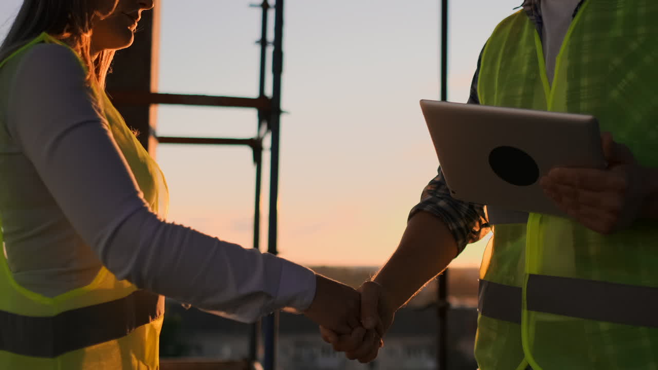 Engineers shake hands to celebrate success day. Engineers shake hands after success day and celebrate success and establish partnership