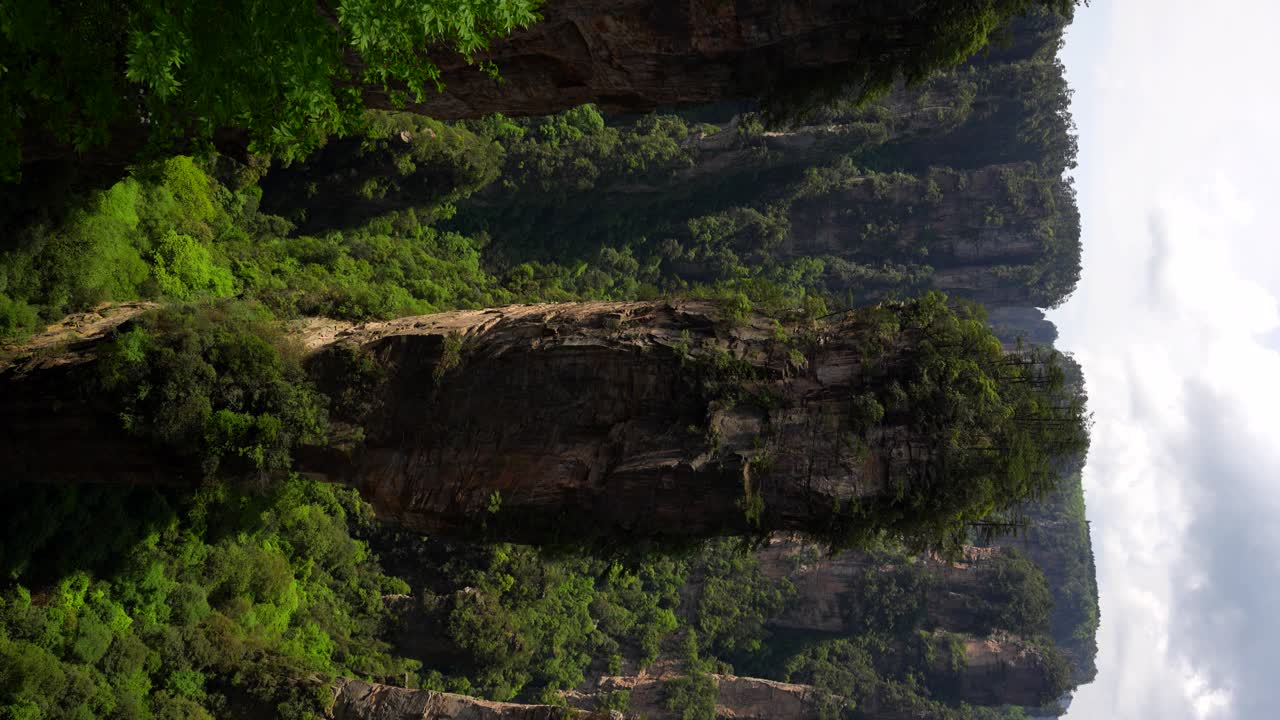 Majestic view of Zhangjiajie's towering South Heaven Pillar surrounded by lush forest. Vertical