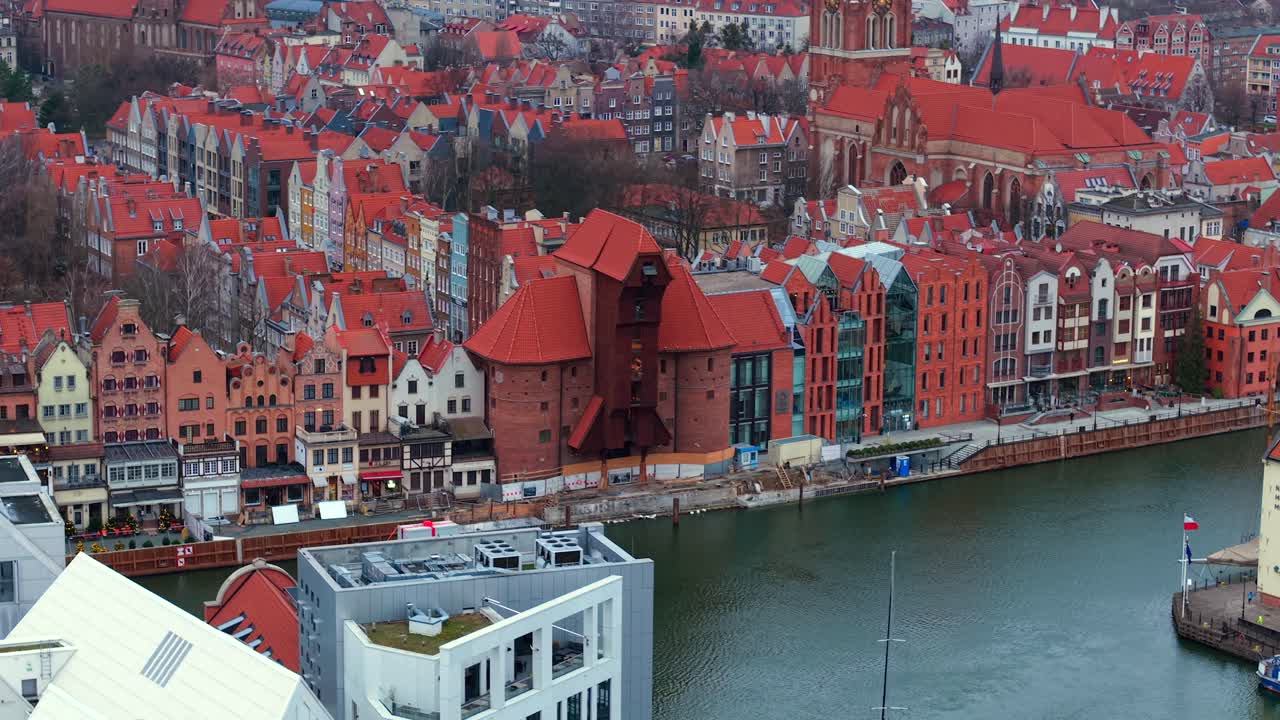 Slow aerial parallax, city waterfront buildings, famous medieval port crane