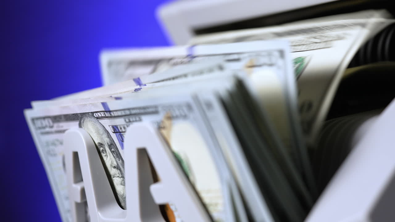 Cash money counting machine. Banknote counter are counting hundred dollar bills. Close-up