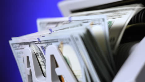 cash money counting machine. banknote counter are counting hundred dollar bills. close-up