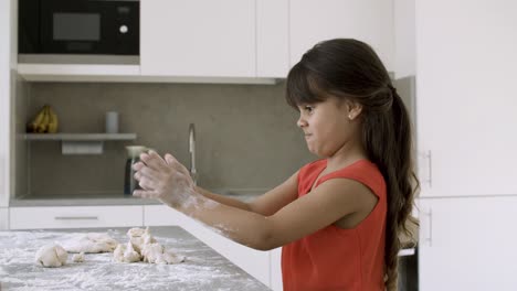 focused funny little girl baking by herself