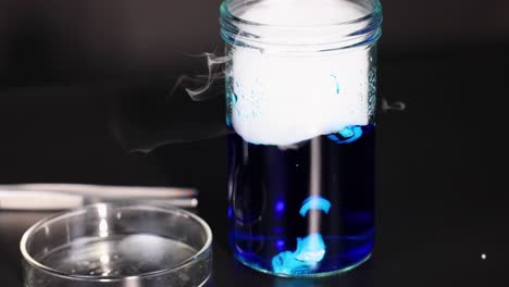 el hielo seco reacciona en el vaso líquido azul
