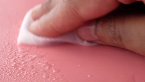 cleaning a wet pink surface with a tissue