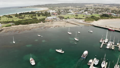 vista aérea de los barcos, en un muelle en la isla de las focas, día nublado, en australia - inclinación hacia arriba, disparo de drones