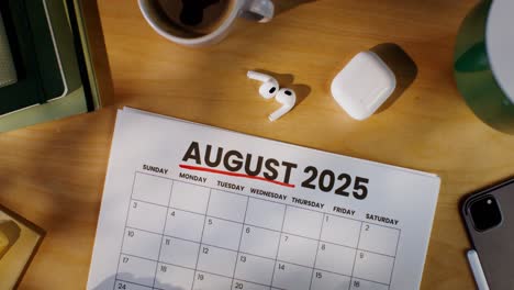 august 2025 calendar on a desk with accessories