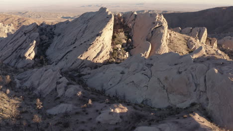 aerial view of dramatic rock formations in a desert landscape at sunset