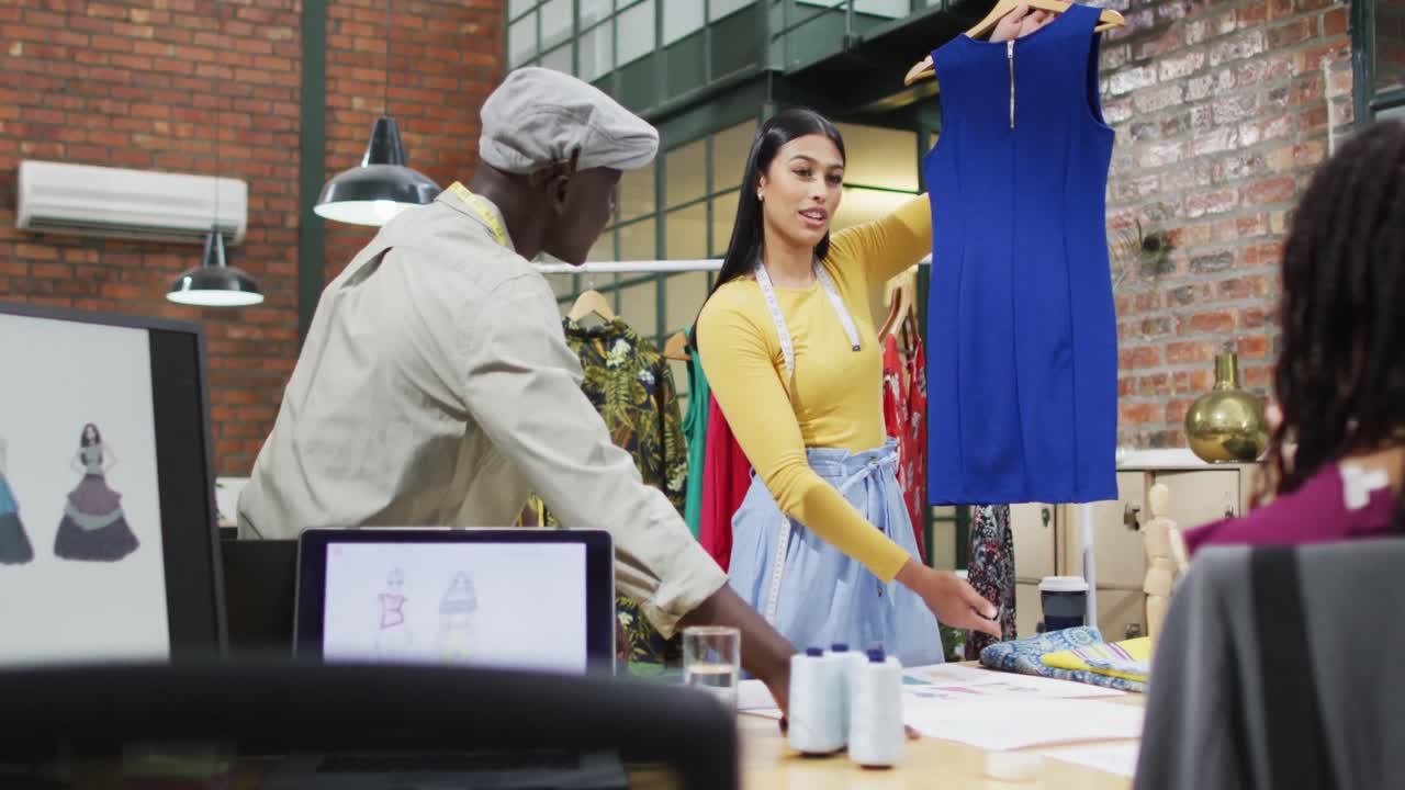diseñadores de moda diversos felices usando las medidas de cinta discutiendo el trabajo en la oficina