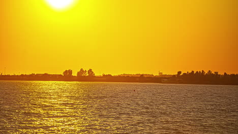 Eine-Zeitrafferaufnahme-Eines-Flusses-Und-Einer-Angrenzenden-Landschaft-Bei-Sonnenuntergang