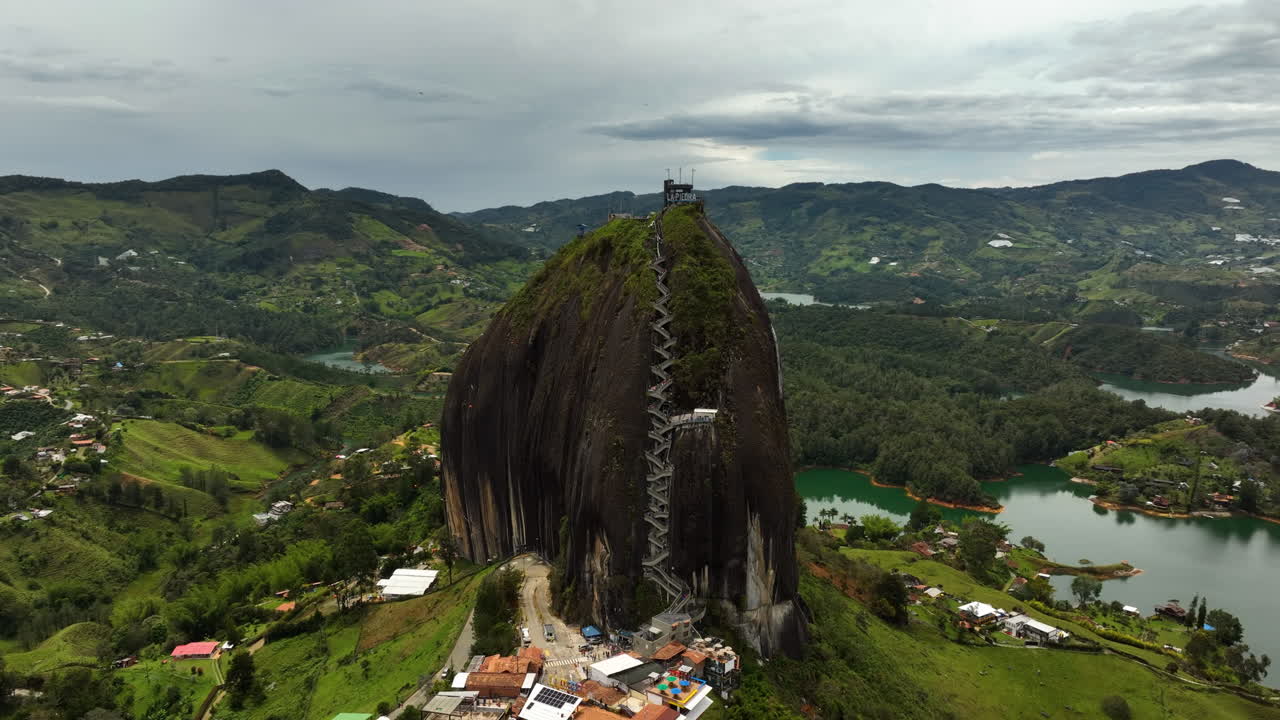 Drone shot around the Piedra del Pe&ntilde;ol monolith, in cloudy Guatape, Colombia
