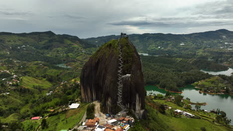 Drohnenaufnahme-Um-Den-Monolithen-Piedra-Del-Peñol-Im-Wolkigen-Guatape,-Kolumbien