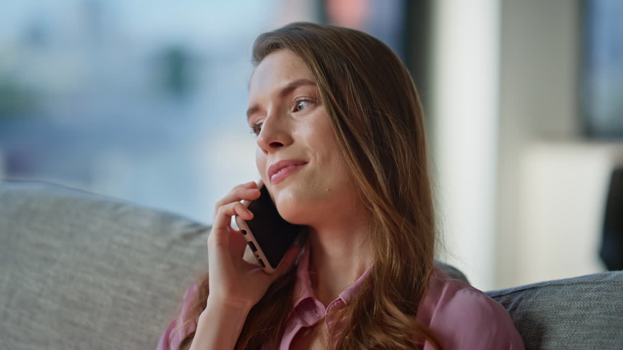 Relaxed brunette talking mobile phone sitting couch closeup. Smiling woman