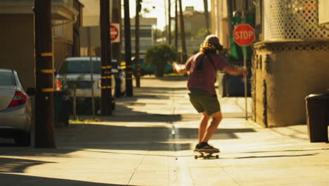 Patinador-Cabalgando-Por-La-Icónica-Calle-Lateral-De-Los-ángeles,-Vista-Trasera