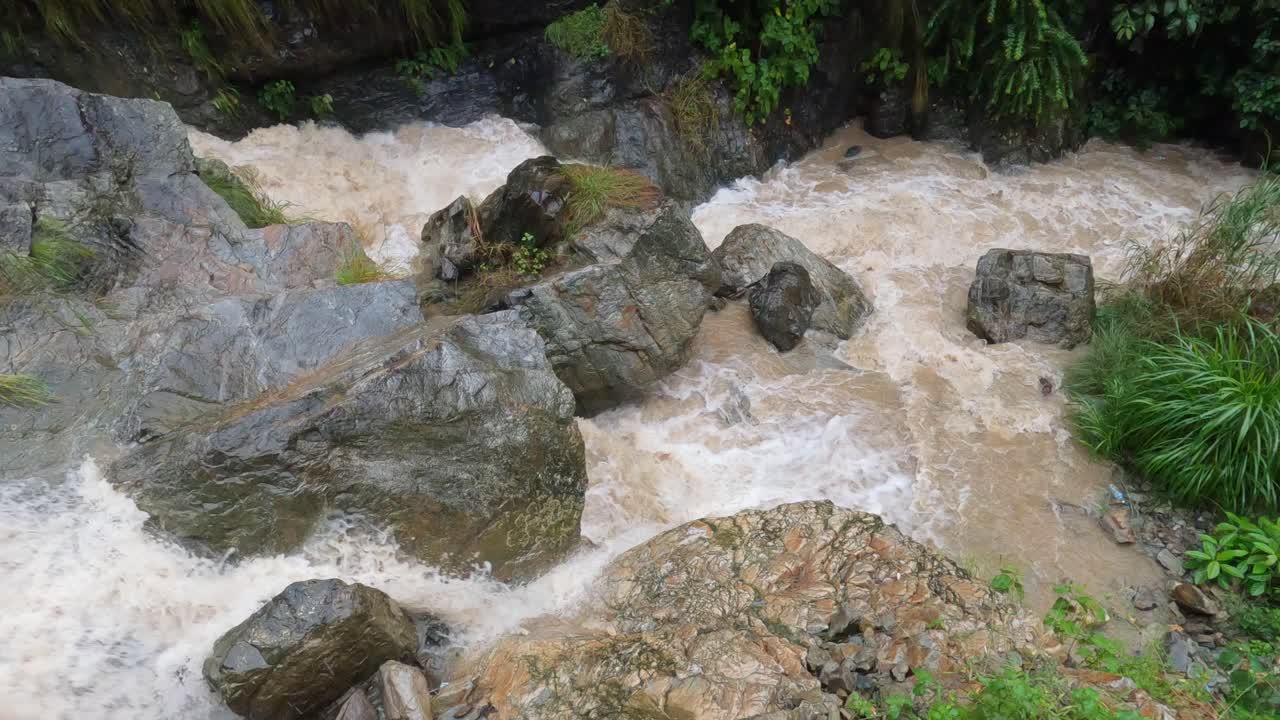 agua que se precipita sobre las rocas de una cascada en las colinas de nepal durante la lluvia de un tifón