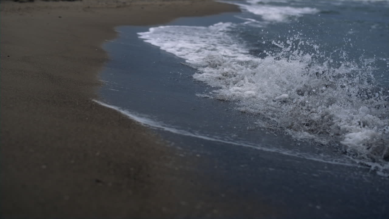 Onde blu che si infrangono sulla battigia della spiaggia sabbiosa, paesaggio. Concetto di natura selvaggia.