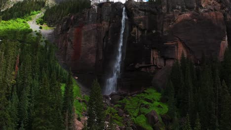 telluride bridal veil falls aerial drone waterfall telluride windy mist spray black bear pass road colorado pine tree ouray ridgway box canyon cliffside 4wd hiking cloudy sun blue sky backwards pan up