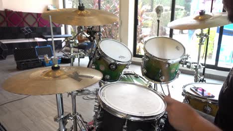 young man playing drums, the video is in slow motion, a music band