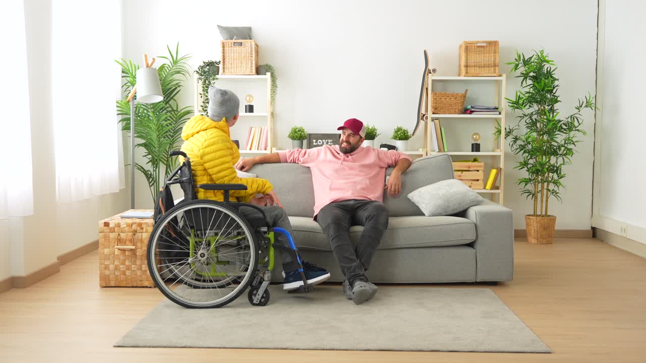 Two friends chatting in the living room, one in a wheelchair