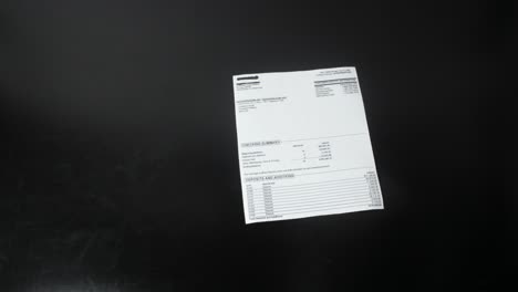 papel de estado de cuenta arrojando en la mesa vista de cerca