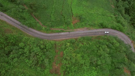aerial view of winding mountain road with motorcycles