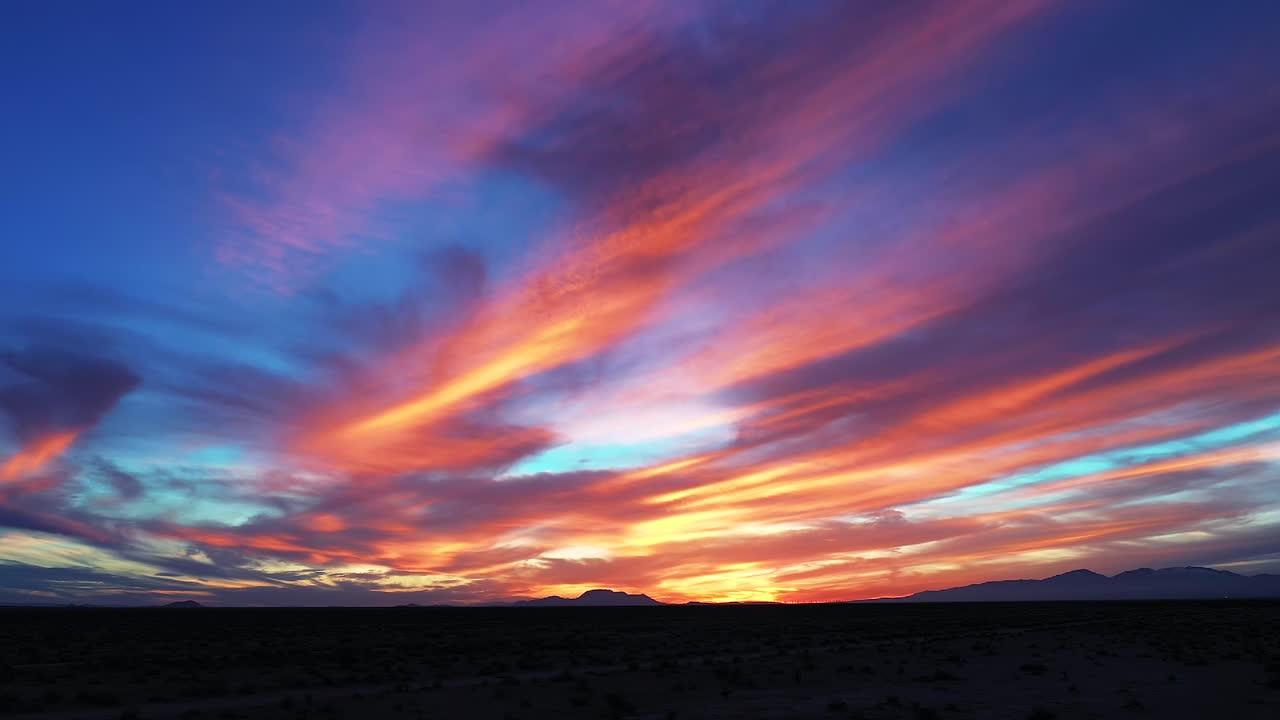el desierto de mojave durante una puesta de sol gloriosamente colorida en una velada romántica - vista aérea deslizante