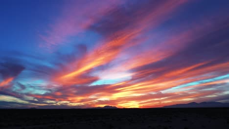 the mojave desert during a gloriously colorful sunset on a romantic evening - sliding aerial view