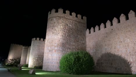 a nighttime scene of avila's historic old town, highlighting the illuminated, unesco-listed medieval walls in spain.