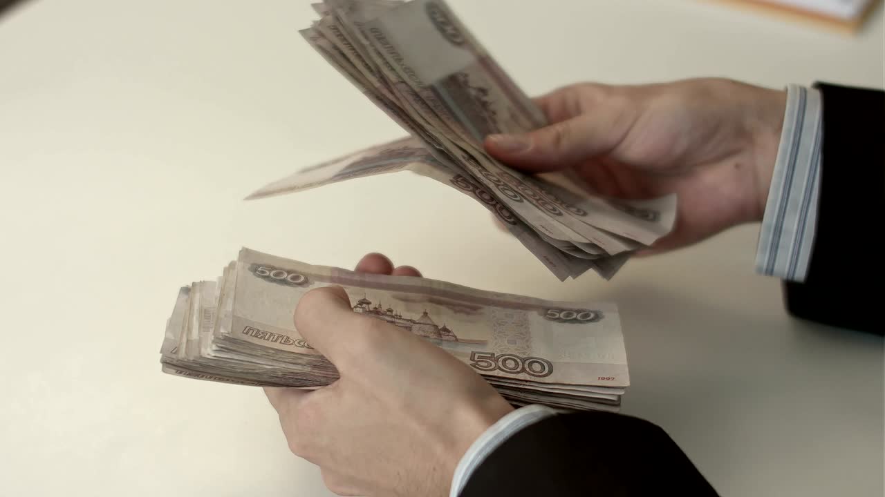 бизнесмен подсчитывает деньги в руках