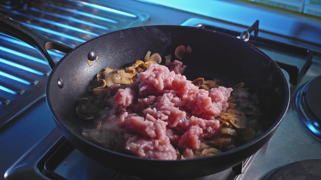 agregando carne de pavo molida magra en una sartén con cebolla y champiñones