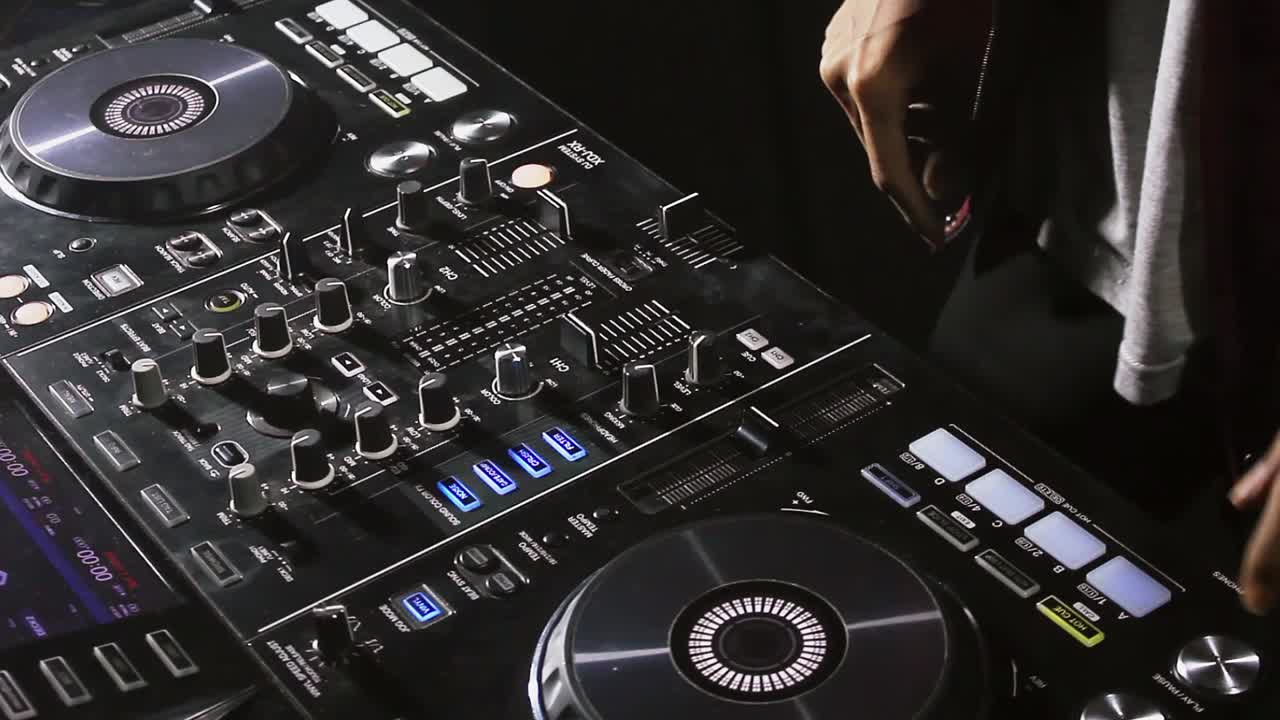 cerrar la mano de dj girando la perilla y haciendo malabarismos entre dos cubiertas de instrumentos de dj