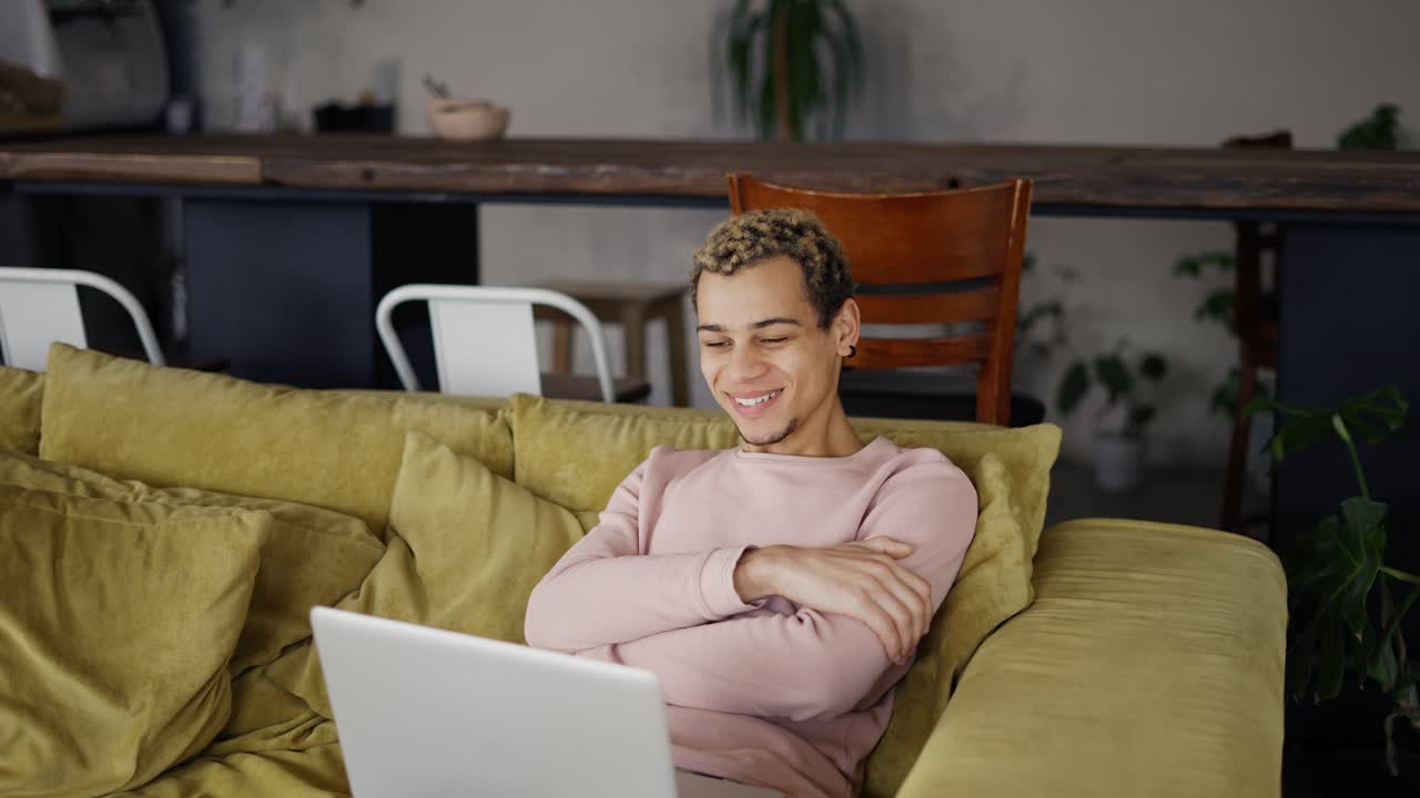 Happy young man laughing talking to friends on video conference or watch the show