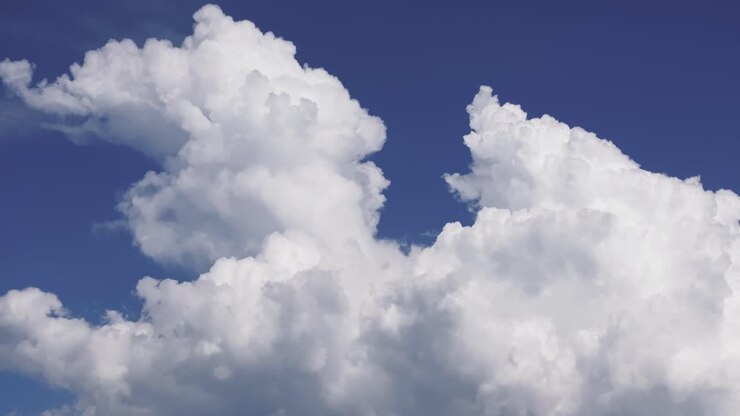 Gathering Of White Fluffy Clouds In Clear Blue Sky