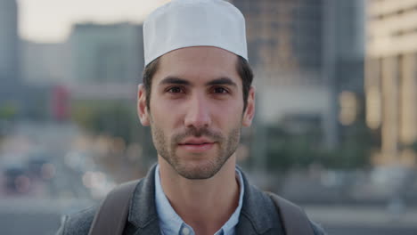 portrait confident young arab businessman turns head smiling enjoying successful urban lifestyle in city at sunset attractive muslim man wearing kufi hat slow motion