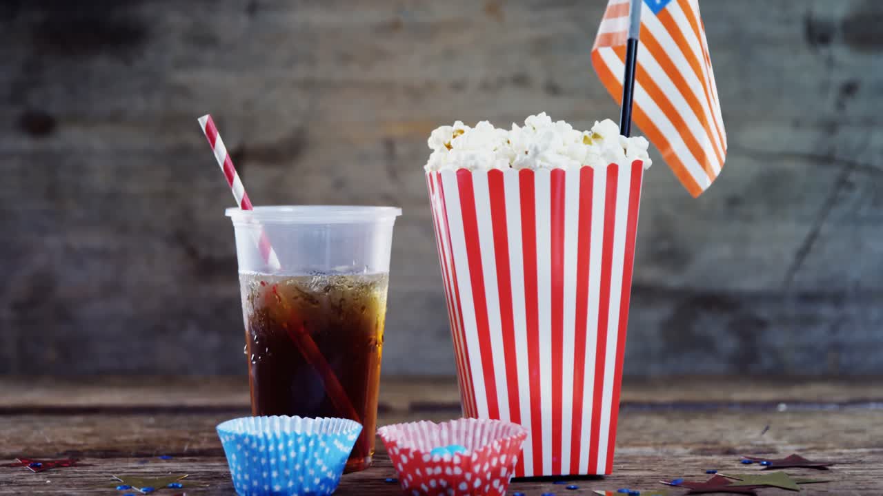 palomitas de maíz, dulces y bebidas en una mesa de madera
