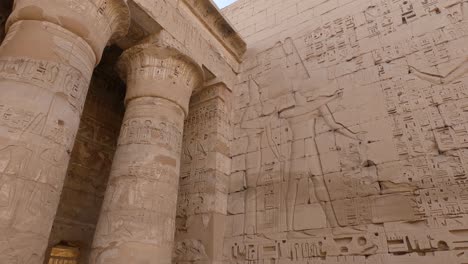 View-of-hieroglyphs-and-drawings-on-the-wall-and-pillars,-archaeological-locality-Medinet-Habu-near-Luxor,-Egypt