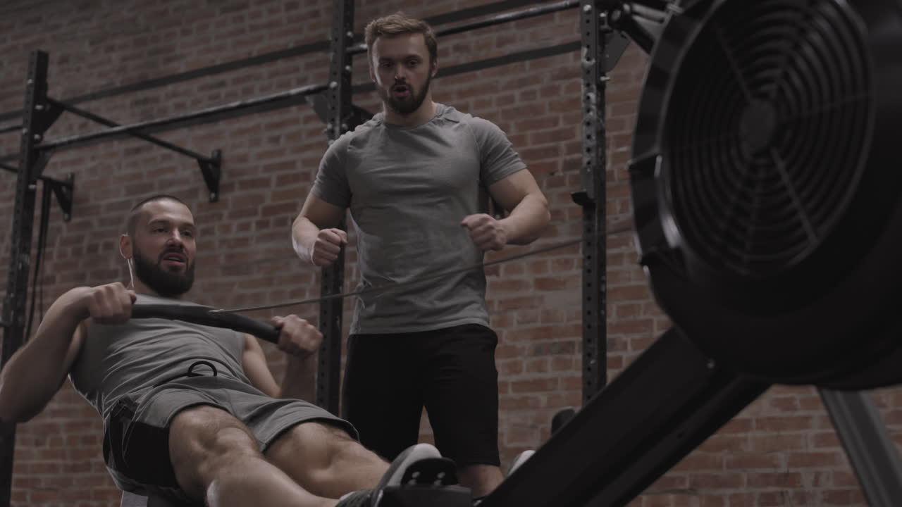 Caucasian Sportsman Exercising on Exercise Machine
