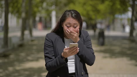 Chica-Sorprendida-Usando-Teléfono-Móvil-En-La-Calle