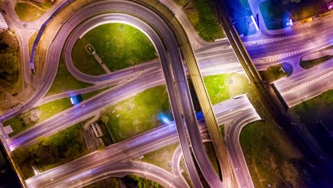 Vista-Aérea-Nocturna-De-Timelapse-De-Una-Intersección-De-Autopistas-Con-Senderos-De-Tráfico-En-Moscú-Nocturna