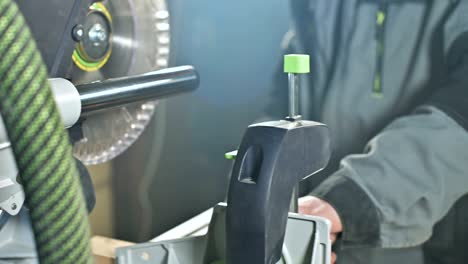 a young carpenter installs a wooden work piece in a circular sawing machine