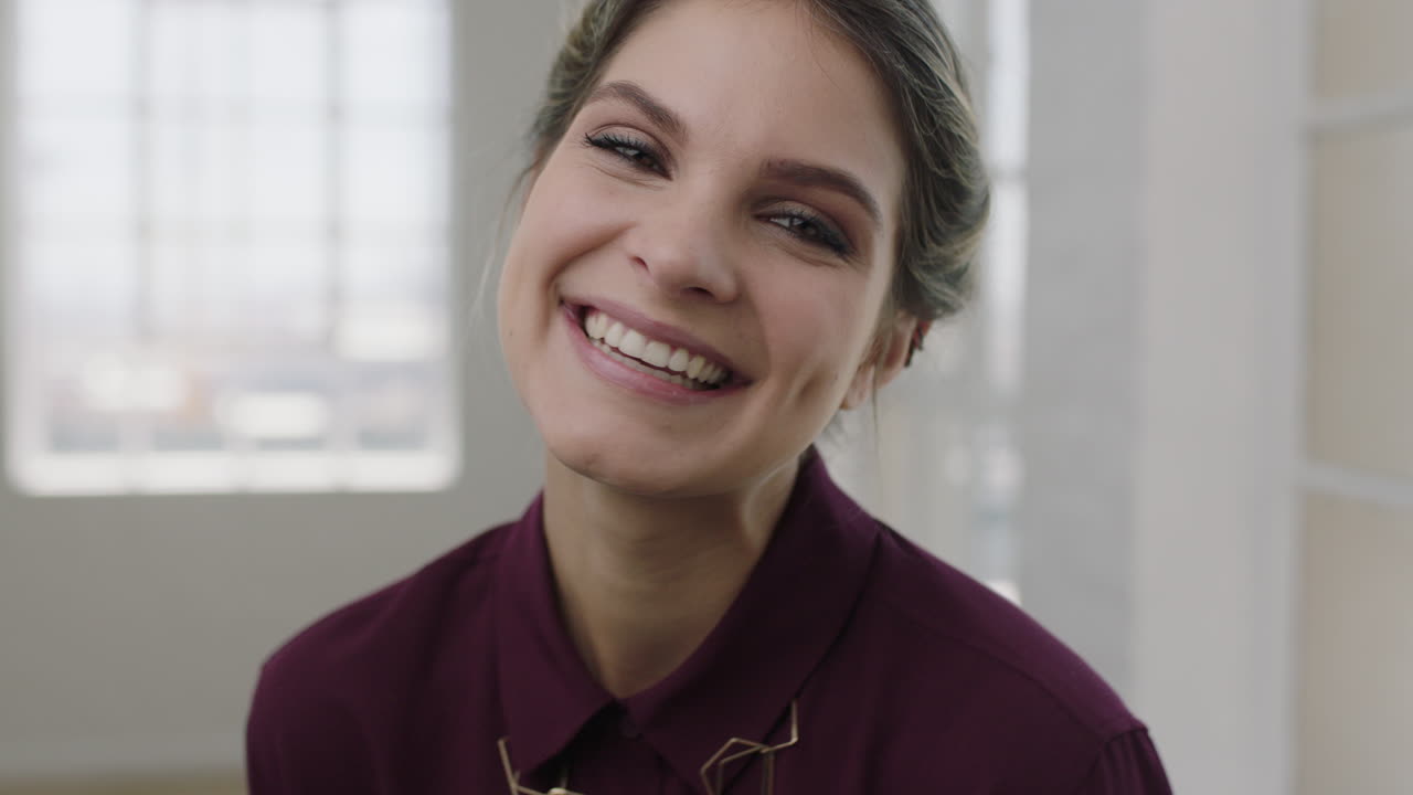 retrato de una mujer hermosa riendo alegremente a la cámara con una blusa elegante mujer caucásica independiente en el fondo del apartamento
