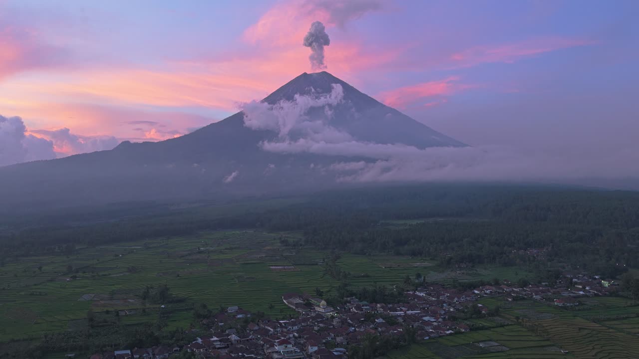 Vulcano Semeru che erutta cenere e fumo al tramonto